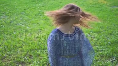 年轻迷人的<strong>女孩</strong>在公园的特写镜头里旋转头发。 慢动作